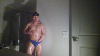 Oiled up and posing while wearing Speedos!