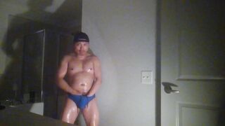 Oiled up and posing while wearing Speedos!