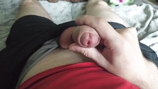 The guy strokes his dick through black shorts and pulls out a dick