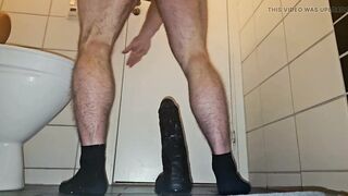 Muscular guy fucking a big black dildo