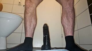 Muscular guy fucking a big black dildo