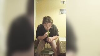 A tattooed gay man in glasses is riding a cucumber!